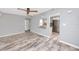 Spacious living room with wood-look tile flooring and an opening to the updated kitchen at 14050 W Parsley Dr, Madeira Beach, FL 33708