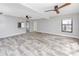 Living room with wood-look tile flooring, ceiling fans, and view to the pass-through kitchen at 14050 W Parsley Dr, Madeira Beach, FL 33708