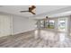 Large living room with wood-look tile flooring, ceiling fans, and water views from the windows at 14050 W Parsley Dr, Madeira Beach, FL 33708