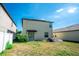 Rear exterior of the home features a sliding glass door and a compact lawn area at 14430 English Lavender Dr, Wimauma, FL 33598
