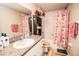Bright bathroom features a granite countertop, decorative accents, and a shower with a floral curtain at 14430 English Lavender Dr, Wimauma, FL 33598