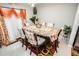 Elegant dining room with seating for six, decorative curtains, stylish floral accents, and bright natural light at 14430 English Lavender Dr, Wimauma, FL 33598