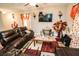 Comfortable living room featuring leather seating, decorative accents, and a ceiling fan at 14430 English Lavender Dr, Wimauma, FL 33598