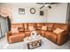 Elegant living room featuring a plush leather sectional, decorative pillows, and stylish decor at 14430 English Lavender Dr, Wimauma, FL 33598