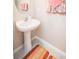 Stylish powder room featuring a pedestal sink, oval mirror, and decorative towels at 14430 English Lavender Dr, Wimauma, FL 33598