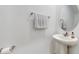 Simple powder room with white pedestal sink, round mirror, and neutral color palette at 15033 Abby Birch Pl, Tampa, FL 33613
