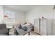 Well-lit bedroom with a gray bedspread, decorative dresser, and large window at 15033 Abby Birch Pl, Tampa, FL 33613