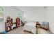 Bright bedroom featuring a twin bed, bookshelves, a desk, and a comfortable armchair at 15033 Abby Birch Pl, Tampa, FL 33613