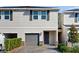 Charming two-story townhouse with gray garage door, stone accents, and manicured landscaping at 15033 Abby Birch Pl, Tampa, FL 33613