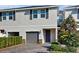 Charming two-story townhouse with gray garage door, stone accents, and manicured landscaping at 15033 Abby Birch Pl, Tampa, FL 33613