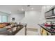 Modern kitchen with a black countertop island featuring a stainless steel sink and white tile flooring at 15033 Abby Birch Pl, Tampa, FL 33613