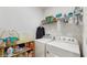 Functional laundry room featuring a washer, dryer, storage shelves, and ample space for organizing supplies at 15033 Abby Birch Pl, Tampa, FL 33613