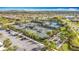 Aerial view showcasing multiple tennis courts, pickleball courts, and shaded seating areas at 15434 Santa Pola Dr, Wimauma, FL 33598