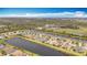 A beautiful aerial view of several single-Gathering homes along a canal with lush green landscaping surrounding them at 15434 Santa Pola Dr, Wimauma, FL 33598