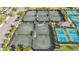 Aerial shot of tennis and pickleball courts, surrounded by palm trees and parking facilities at 15434 Santa Pola Dr, Wimauma, FL 33598