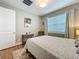Serene bedroom with natural light, minimalist decor, hardwood flooring, and a cozy rug for added warmth at 15434 Santa Pola Dr, Wimauma, FL 33598