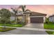 Beautiful single-story home with a paver driveway, tropical landscaping, and a tile roof in a well-maintained neighborhood at 15434 Santa Pola Dr, Wimauma, FL 33598