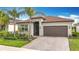 Attractive one-story home boasting a paver driveway, well-maintained landscaping, and a warm, inviting facade at 15434 Santa Pola Dr, Wimauma, FL 33598