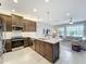 Bright kitchen boasts stainless appliances, a center island, and an open layout to the living area at 15434 Santa Pola Dr, Wimauma, FL 33598