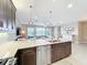 Contemporary kitchen with stainless steel dishwasher, a large island, and pendant lighting at 15434 Santa Pola Dr, Wimauma, FL 33598