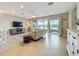 Inviting living room with a neutral sofa, patterned rug, and sliding glass doors offering a view of the water at 15434 Santa Pola Dr, Wimauma, FL 33598