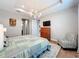 Serene main bedroom featuring a tray ceiling, ample lighting, and hardwood floors that complement the furniture at 15434 Santa Pola Dr, Wimauma, FL 33598