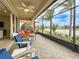 Enclosed patio featuring comfortable seating, ceiling fan, and scenic water view at 15434 Santa Pola Dr, Wimauma, FL 33598