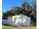 Detached one car metal garage with door to side and roll up door in backyard at 1731 Joe Mcintosh Rd, Plant City, FL 33565