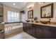 Bathroom with double vanity, vessel sinks, soaking tub, and decorative tile accents at 18823 Avenue Biarritz, Lutz, FL 33558