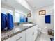 Bright bathroom featuring a granite countertop vanity and blue accent towels at 197 Rain Berry Ave, Ruskin, FL 33570