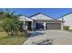Inviting home featuring a two-car garage, covered porch, and low maintenance landscaping at 197 Rain Berry Ave, Ruskin, FL 33570