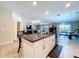 Open concept kitchen features a granite island, seating, and a view into the dining room and living spaces at 197 Rain Berry Ave, Ruskin, FL 33570