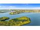 Majestic aerial captures a lush island community, surrounded by tranquil water and featuring a sailboat at 2077 N Pointe Alexis Dr, Tarpon Springs, FL 34689