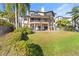 Lush green backyard with mature trees leading to scenic waterfront views, perfect for outdoor enjoyment at 2077 N Pointe Alexis Dr, Tarpon Springs, FL 34689