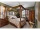 Cozy bedroom featuring a four-poster bed, soft lighting, and warm decor at 2077 N Pointe Alexis Dr, Tarpon Springs, FL 34689