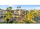Elegant waterfront property with a swimming pool, multiple balconies, and lush tropical landscaping at 2077 N Pointe Alexis Dr, Tarpon Springs, FL 34689