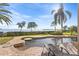 Gorgeous pool area with waterfront views, lush palms, and inviting lounge chairs, perfect for relaxation at 2077 N Pointe Alexis Dr, Tarpon Springs, FL 34689