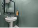 Stylish powder room featuring a pedestal sink, ornate mirror, and warm, neutral paint at 21181 Threadfin Way, Land O Lakes, FL 34638
