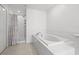 Clean bathroom with a large soaking tub, a shower, and a tiled floor at 21181 Threadfin Way, Land O Lakes, FL 34638