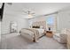 Light-filled main bedroom showcasing a plush bed, large windows, ceiling fan, and soft neutral tones at 21181 Threadfin Way, Land O Lakes, FL 34638