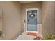 Charming blue front door with wreath, textured wall, and accent mat at 21181 Threadfin Way, Land O Lakes, FL 34638
