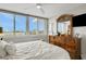 Bright main bedroom featuring large windows with city views, a wooden dresser and fan at 223 Island Way # 7H, Clearwater, FL 33767