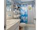 Bathroom featuring a sink, toilet, white tile, and a shower with a cloud-patterned curtain at 2370 Jamaican St # 30, Clearwater, FL 33763