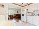 An efficient kitchen featuring white appliances and tile floors, leading to a living area at 2370 Jamaican St # 30, Clearwater, FL 33763