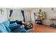 Cozy living room featuring wood floors, blue furniture, and a television at 2370 Jamaican St # 30, Clearwater, FL 33763
