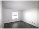 Bedroom featuring wood floors, a window with white curtains, and neutral walls at 2651 Michael Pl # 102, Dunedin, FL 34698