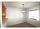 Dining space with a hanging light fixture next to the pass through kitchen bar at 2651 Michael Pl # 102, Dunedin, FL 34698