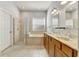Bathroom with double sinks, wood cabinets, granite countertop, tub, and glass shower stall at 3510 Brook Crossing Dr, Brandon, FL 33511