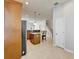 Open-concept kitchen with island, and stainless-steel refrigerator, seamlessly connecting to the living area and staircase at 3510 Brook Crossing Dr, Brandon, FL 33511