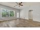 Bright living room showcasing wood-look floors, neutral walls, ceiling fan, and a door leading outside at 3510 Brook Crossing Dr, Brandon, FL 33511